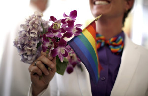 Faith Kassan, 46, holds a rainbow flag with her bouquet before getting married to her fiancee Jennifer Ehrman in West Hollywood