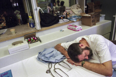 Weary from examining hundreds of children, a member of the team from Houston takes a short break before resuming work.